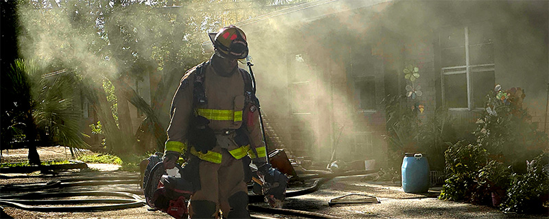 Firefighter walking with smoke after a fire